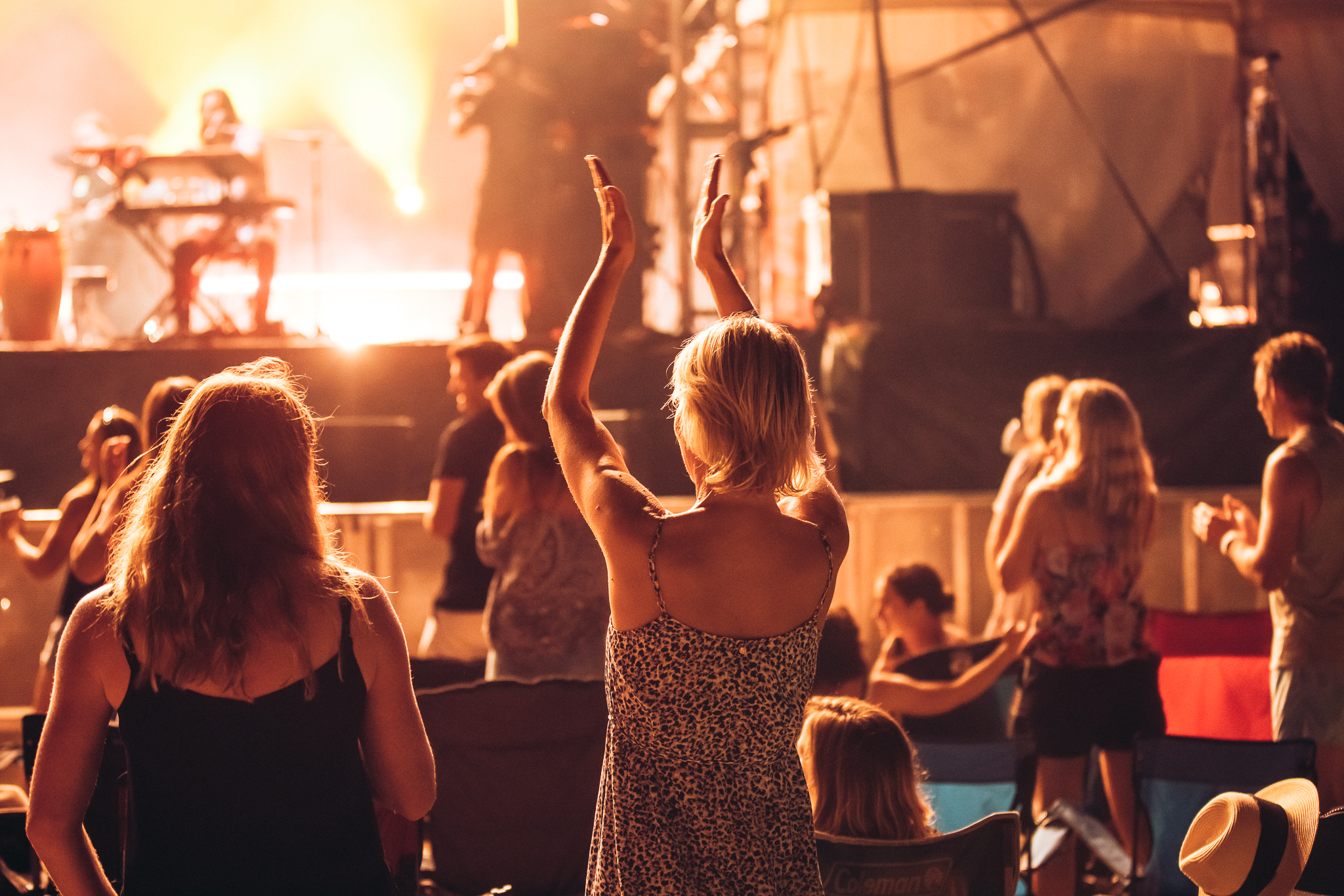 Woman in front of stage clapping with performance in background